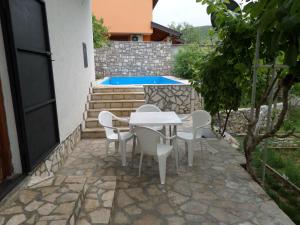 a patio with a table and chairs and a pool at Holiday Home Iris in Blagaj