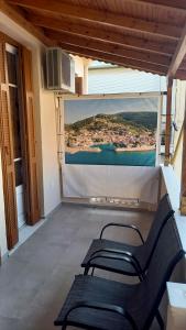 a balcony with two chairs and a wall with a painting at my own way in Nafpaktos