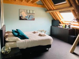 a bedroom with a bed with blue pillows on it at B&B with or without De Schuur in Zierikzee