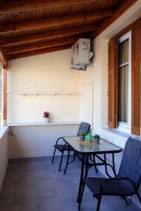 a patio with a table and chairs and a window at my own way in Nafpaktos