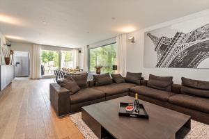 a living room with a couch and a table at Villa Stuifduin in Oostduinkerke