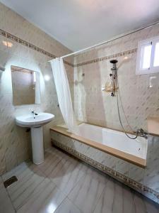 ein Badezimmer mit einem Waschbecken, einer Badewanne und einem Waschbecken in der Unterkunft Residencial Portonovo in Portonovo