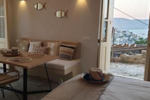 a room with a couch and a table and a window at Boho luxury studio in Kali Strata in Symi