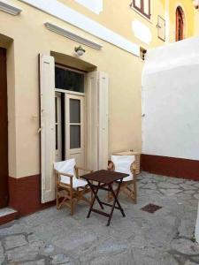 a table and chairs sitting outside of a building at Boho luxury studio in Kali Strata in Symi