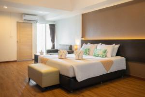 a bedroom with a large bed and a chair at Golden Jade Suvarnabhumi in Lat Krabang