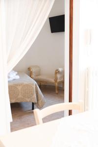 um quarto com um sofá, uma cadeira e um espelho em Trullo Dimora Zaccaria em Alberobello