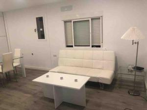a living room with a white couch and a table at Gran apartamento en el centro in Almería