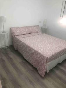 a bedroom with a bed with a pink bedspread at Gran apartamento en el centro in Almería