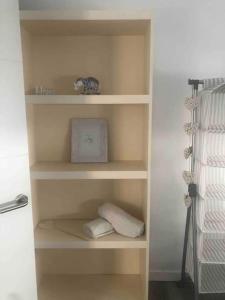 a book shelf with towels and a clock in a bedroom at Gran apartamento en el centro in Almería