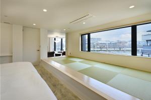 a bedroom with a bed and a large window at Mont-モン-KAMOGAWA STAY and HOTEL in Kyoto