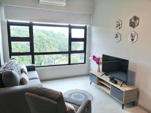 a living room with a couch and a television at City View with Jesselton Quay Near Suria Sabah Mall & Jesselton Point in Kota Kinabalu