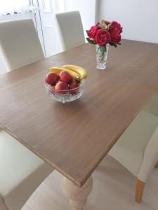 a bowl of fruit on a wooden table with a vase of flowers at Apartment Elizabeth in Split