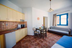 a kitchen with a couch and a table in a room at Iliana Hotel in Panormos Rethymno