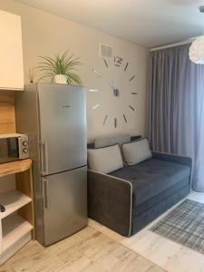 a room with a refrigerator and a clock on the wall at Квартал in Khmelnytskyi