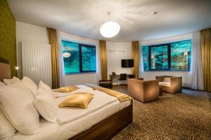 Rimske Terme Resort - Hotel Rimski dvor في ريمسكي توبليتسي: غرفة نوم بسرير كبير وغرفة معيشة