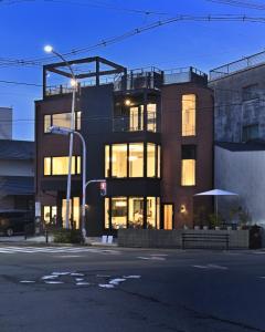 a building on a city street at night at Mont-モン-KAMOGAWA STAY and HOTEL in Kyoto