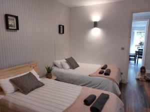 2 camas en un dormitorio con un niño sentado en el suelo en Getxo Beach Apartment by Getxo Garden Houses en Getxo