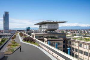 a person walking down a walkway on top of a building at DoubleTree by Hilton Turin Lingotto in Turin