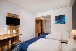 a hotel room with two beds and a flat screen tv at Holiday Inn Express Bremen Airport by IHG in Bremen +38 photos