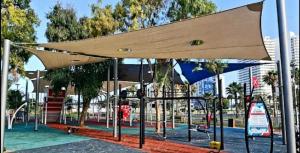 a bus stop with awning at a playground at Motel Hofim in Bat Yam
