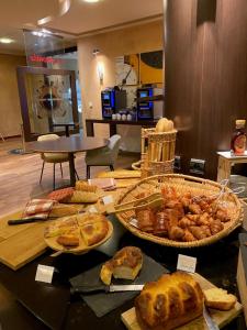a table with many different types of bread and pastries at Mercure Besancon Parc Micaud - Hotel & Bar in Besançon