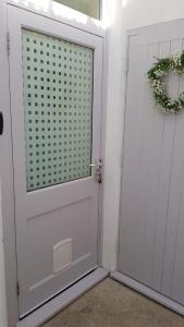 een witte deur met een krans erop bij The Seawitch - harbourside apartment in Mousehole