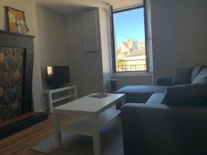 ein Wohnzimmer mit Couch und Kamin in der Unterkunft Le calme au coeur de Chauvigny in Chauvigny