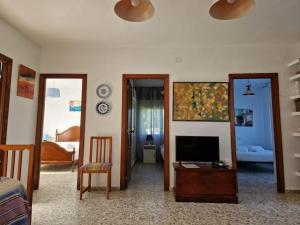 sala de estar con TV y dormitorio en Casa Suricato, en San Vicente do Mar