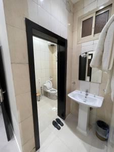 a bathroom with a sink and a toilet at قصر الجادل للشقق المخدومة in Ahad Rafidah