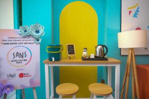 a table with two stools next to a surfboard wall at Sans Hotel City Inn Solo by RedDoorz in Solo