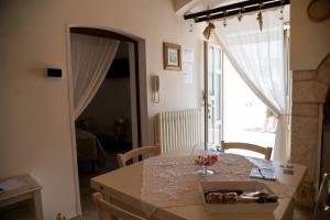 uma sala de jantar com uma mesa e uma grande janela em Trullo Dimora Zaccaria em Alberobello