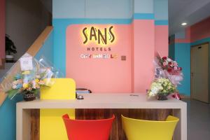 una habitación con sillas coloridas y un mostrador con una señal en Sans Hotel City Inn Solo by RedDoorz en Solo