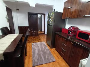 a kitchen with a black refrigerator and a table at Acasă in Drobeta-Turnu Severin