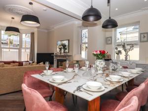 uma sala de jantar com uma mesa longa e cadeiras em Bradley House em Ilfracombe