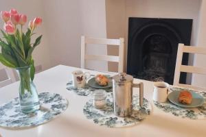 Una mesa con platos de comida y un jarrón de flores. en The Portpatrick Pad - A cosy 3 bed cottage, w. sea views & garden office, en Portpatrick 27 fotos más
