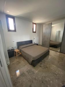 Un dormitorio con una cama y una mesa y ventanas. en Casa Royal, en Ausonia