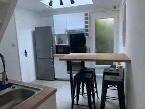 eine Küche mit einem Tisch, Stühlen und einem Kühlschrank in der Unterkunft Le calme au coeur de Chauvigny in Chauvigny