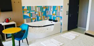 a bathroom with a tub and a table and a stool at HOTEL HOUSE GARGANO in San Giovanni Rotondo