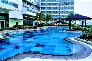 uma grande piscina em frente a um edifício em Stylish Luxe Apartment very near Makati Square em Manila