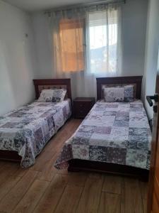 sypialnia z 2 łóżkami i oknem w obiekcie Appartement Niché au cœur de Bejaia w mieście Bidżaja