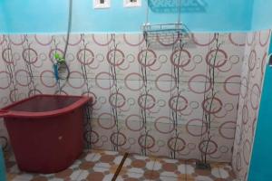 a bathroom with a trash can and a shower curtain at OYO 91477 Fazira Home Stay Syariah in Halangan