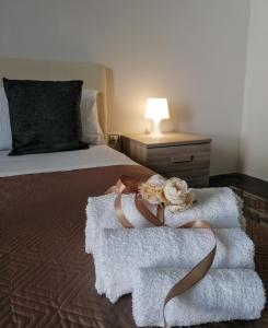 1 dormitorio con 1 cama con toallas y 1 lámpara en Le Tre Rose di Roberta, en Alezio