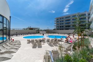 a group of people sitting in chairs by a pool at POLANKI AQUA Apartamenty PREMIUM - w cenie nielimitowany dostęp do strefy Aqua in Kołobrzeg