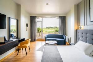 una habitación de hotel con una cama y una silla en Abba Comillas Hotel, en Comillas