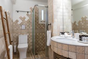 a bathroom with a sink and a toilet at Calma Beach House in Elia Beach