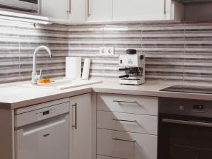 a kitchen with white cabinets and a sink at Szilas Lak in Budapest