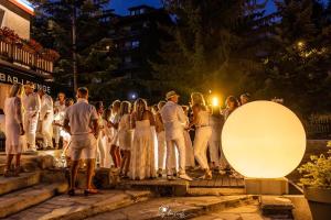 Un groupe de personnes debout devant une foule la nuit dans l'établissement Hôtel 16 | 150 Montagne & Spa Nuxe, à Vars