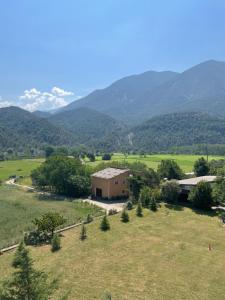 un edificio en un campo con montañas en el fondo en Apartamento con estupendas vistas a Coll de Nargó, en Coll de Nargó