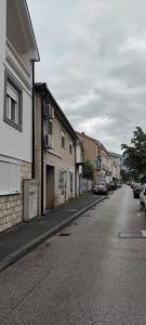 una calle vacía con edificios y coches aparcados en ella en Apartments Golden Bridge en Mostar