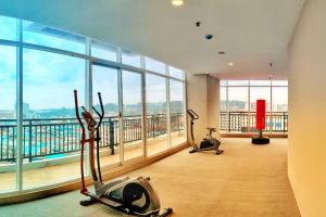 a gym with two exercise bikes in a room with windows at Lovina 23-09 at Formosa Residence in Nagoya